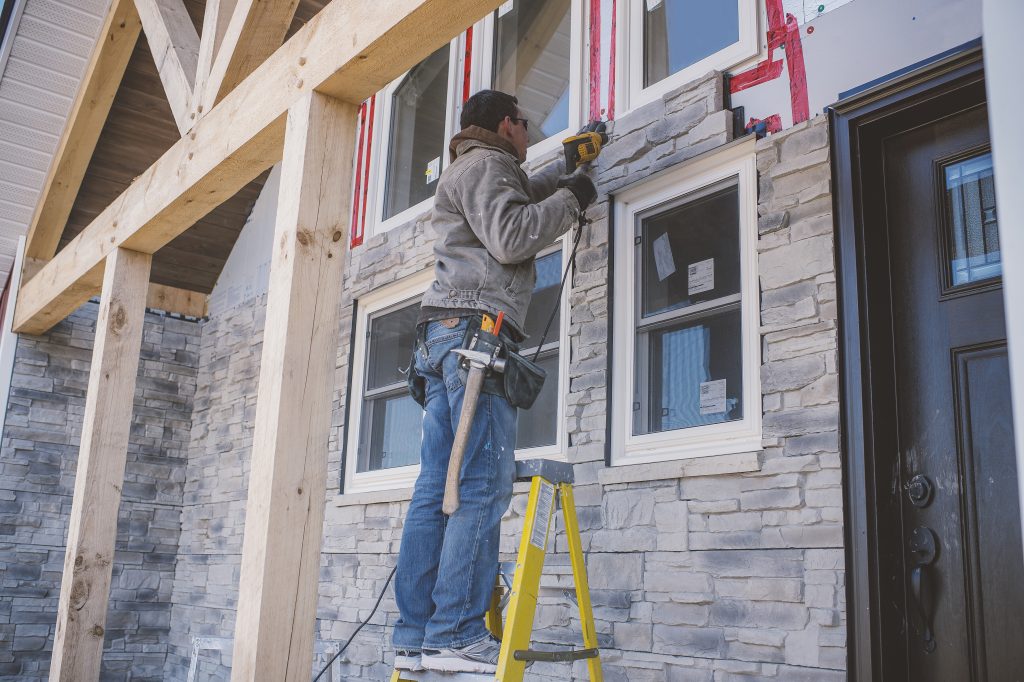 Crew installing new vinyl siding on a Lake Geneva home