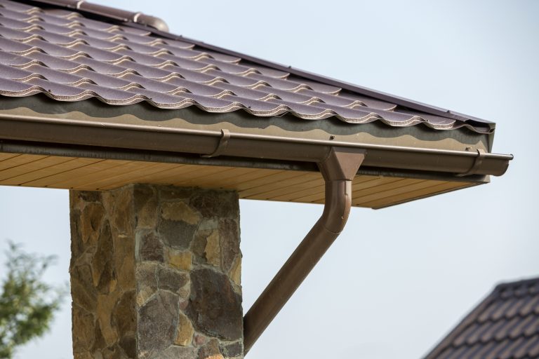 Roofline and siding view of home with installed gutter guards